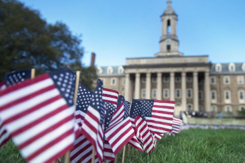 Many small U.S. flags on Old Main lawn.